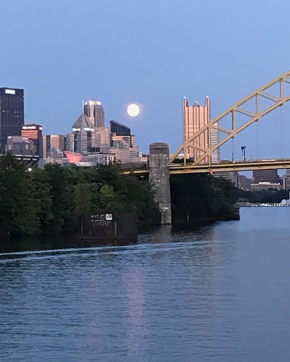 Full moon rising over the Pittsburgh skyline and the Fort Duquesne Bridge at dusk